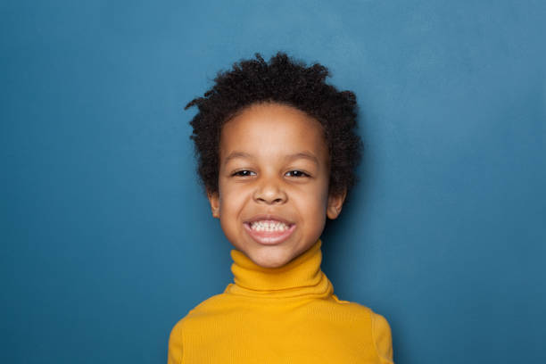 istock Funny black kid boy on blue background portrait 1248564411