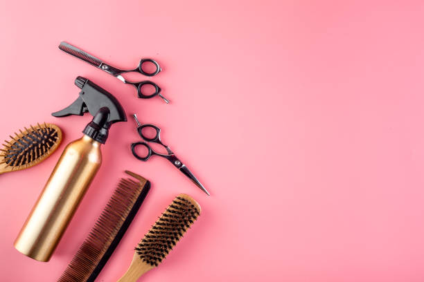 istock Hairdressing instruments. Combs, scissors and spray on pink desk from above frame space for text 1248564432