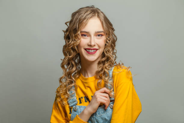 istock Young blonde woman smiling on gray background 1248564794