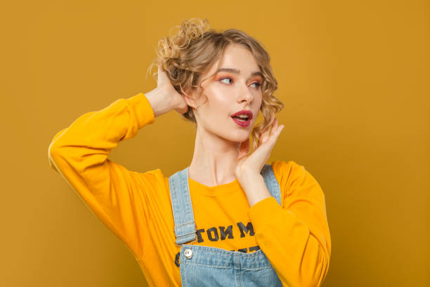 istock Attractive woman in yellow sweatshirt on bright background 1248564815