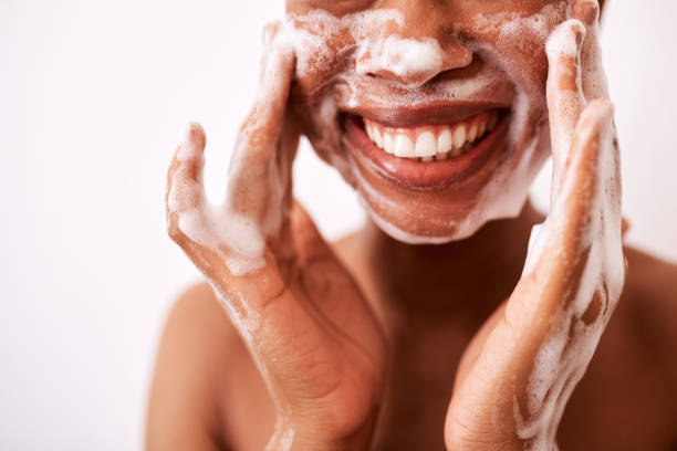 I wash my face twice a day Studio shot of an unrecognizable woman washing her face against a white background woman washing face stock pictures, royalty-free photos & images