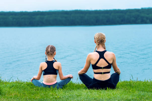 istock Mother and daughter doing yoga exercises 1248568299