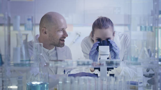 istock Working in modern labolatory. Woman and man joking during research 1248569366