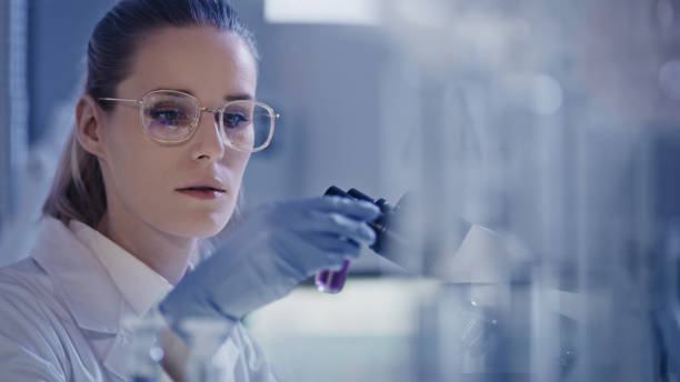 istock Attractive female microbiologist during research. Using microscope in futuristic lab 1248569401