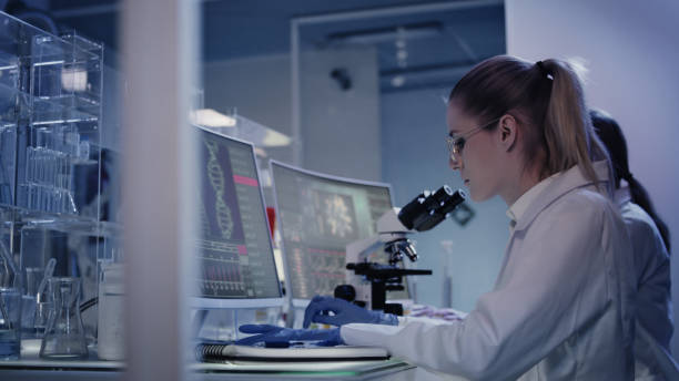 istock Female research team studying DNA mutations. Computer screens with DNA helix in foreground 1248569492