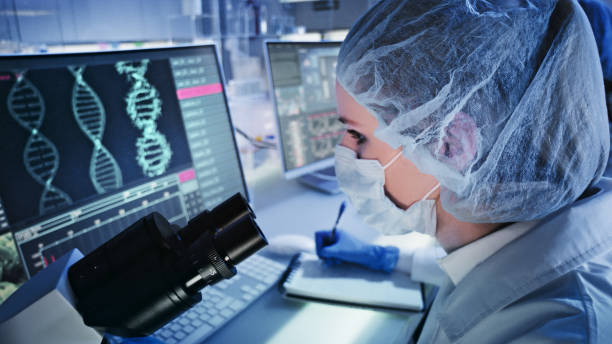 Female doctor studying DNA mutations. Computer screens with DNA helix in foreground Scientist examines DNA models in modern Genetic Research Laboratory. genetic screening stock pictures, royalty-free photos & images