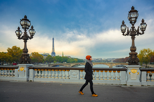 Woman on Pont des Arts bridge in Paris with Eiffel tower in a background