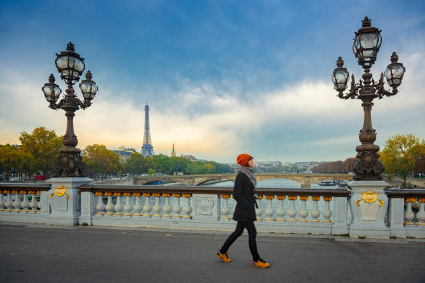woman walking on a bridge in paris - seine river paris france france famous place imagens e fotografias de stock