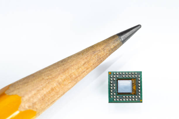 Size comparison of a microelectronic board and the tip of a pencil. White background. Studio shot.