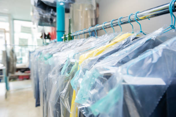 Clean clothes on hangers in the laundry room protected with plastic Clean clothes on hangers in the laundry room protected with plastic dry cleaner stock pictures, royalty-free photos & images