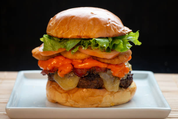 istock hamburger sandwich with melted cheese filling and bacon and cheddar and onion ring with lettuce and tomato on top and bread 1248572968