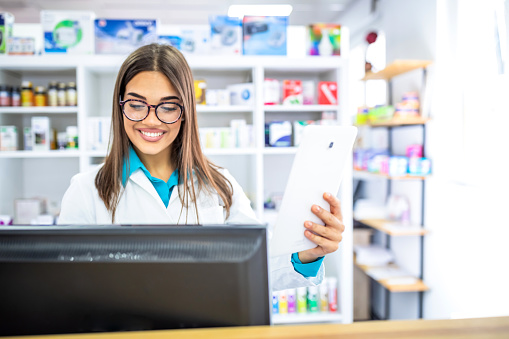 Portrait of pharmacist holding digital tablet in pharmacy