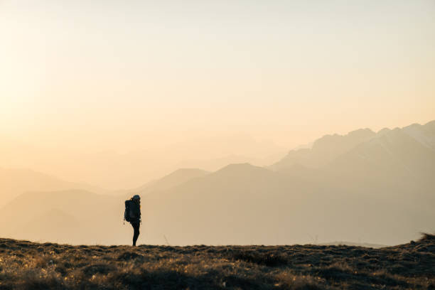 istock Female hiker watches sunrise 1248573193