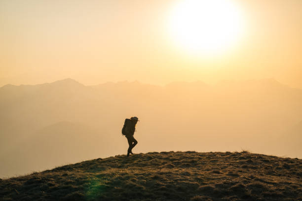 istock Female hiker watches sunrise 1248574056
