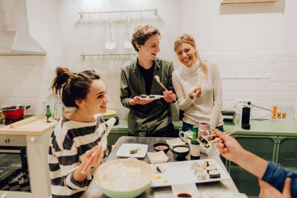 Friends eating sushi in the kitchen