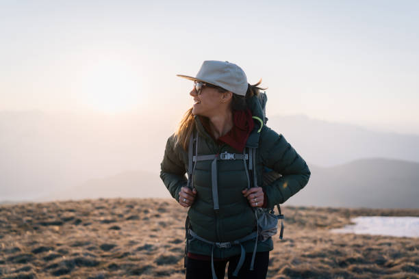 istock Young woman hikes across grassy mountain ridge 1248583397