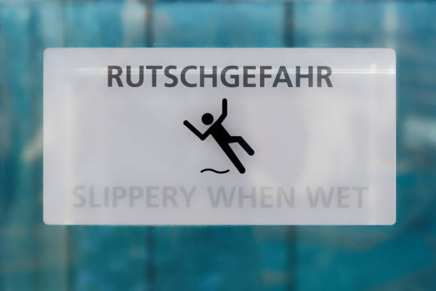 White warning sign slippery when wet written in German and English