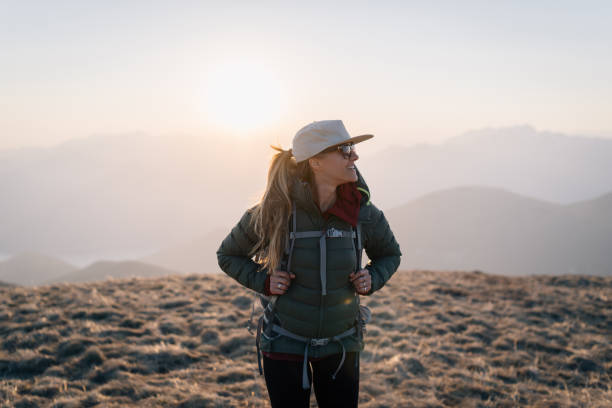 istock Young woman hikes across grassy mountain ridge 1248583851