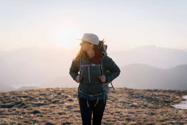 istock Young woman hikes across grassy mountain ridge 1248585205