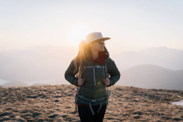 istock Young woman hikes across grassy mountain ridge 1248585292