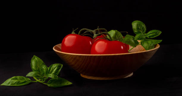 istock Tomatoes a basil in wooden bowl 1248585445