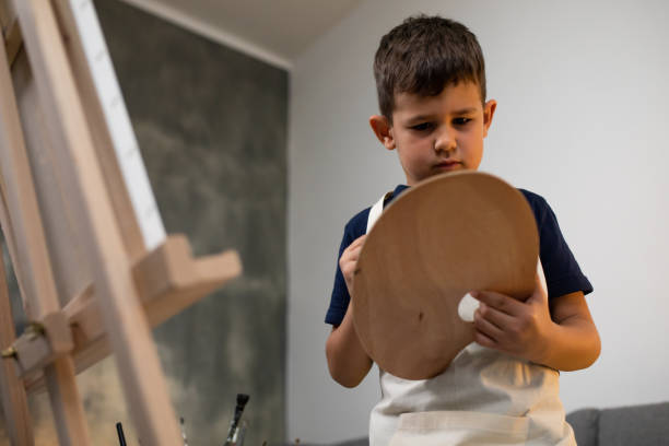 istock A cute boy mixing colors on a palette 1248585636