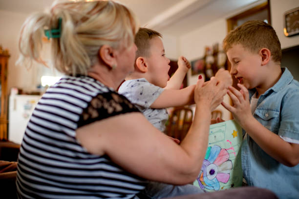 Grandmother and grandsons playing with bubbles, enjoying family time in the garden