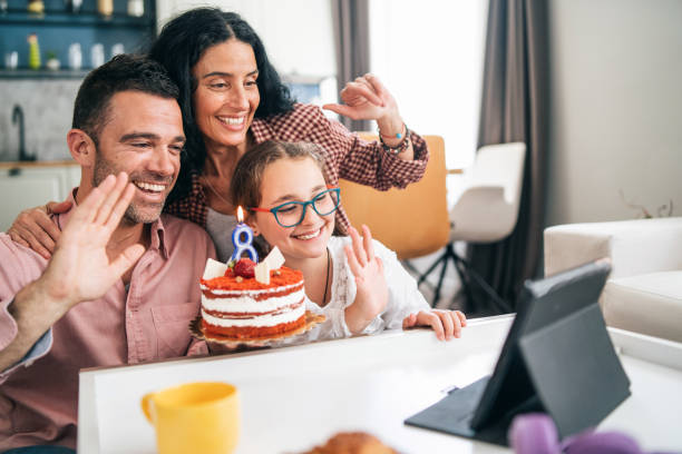 familia celebrando el cumpleaños con videoconferencia en aislamiento domiciliario debido a la pandemia de covid-19 - cake birthday domestic kitchen child fotografías e imágenes de stock