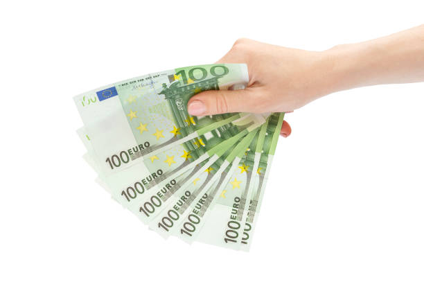 Woman's hand holding one hundred euro banknotes. Isolated on white. stock photo