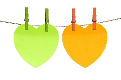 Orange and green blank reminders are hanging on rope photographed on white background