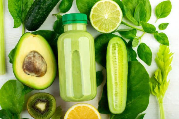 istock Bottle filled with fresh green smoothies cocktail surrounded by ripe vegetables 1248597446