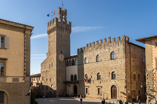 Arezzo, Tuscany, Italy, December 2019: Palazzo dei Priori and its clock tower. Seat of the Town Hall of Arezzo, is located in Piazza della Liberta. Built in the 14th century