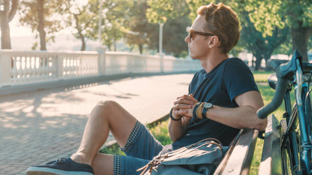 istock Young man cyclist rests on a bench near bicycle. 1248597563
