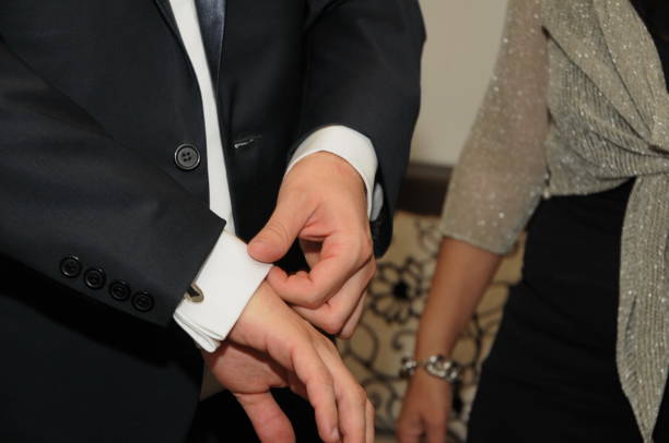 istock helps groom to put on cufflinks close up 1248604428