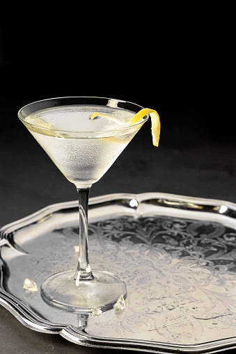 Martini with a lemon twirl on a silver tray