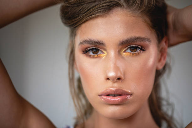 istock Sensual woman with gold eye shadow looking at the camera 1248607866
