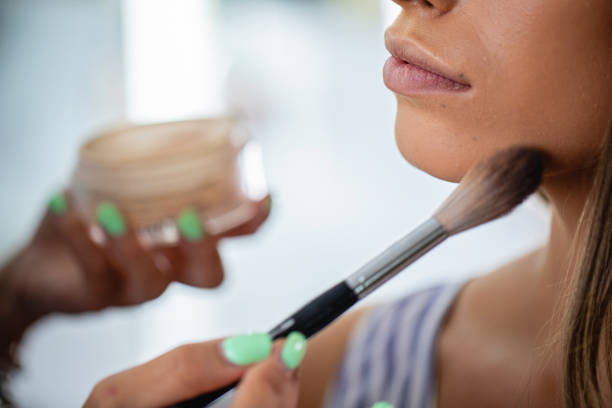 istock Woman putting on skin powder on her make-up client 1248607869