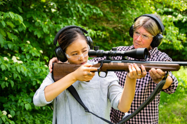 istock A young woman learning to target shoot with a rifle. 1248609271