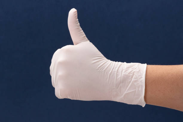 Medical gloves with hand of a woman showing thumbs up Medical gloves with right hand of a woman showing thumbs up left handed catcher stock pictures, royalty-free photos & images
