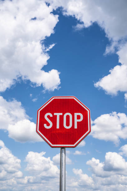istock Stop sign over a blue sky with white fluffy clouds background. Traffic sign. 1248623893