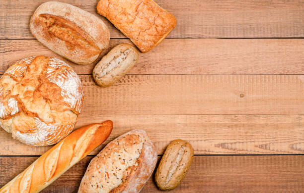 istock Bakery - various rustic crisp loaves of bread and rolls on wooden boards. 1248624724