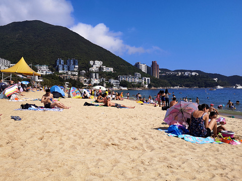 People sunbathing on Repulse Bay beach, on Hong Kong island South coast idyllic bay.