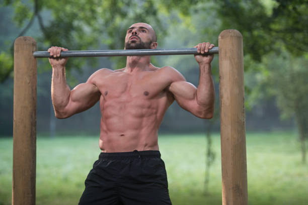 chin ups workout in park - exercising men push ups muscular build imagens e fotografias de stock