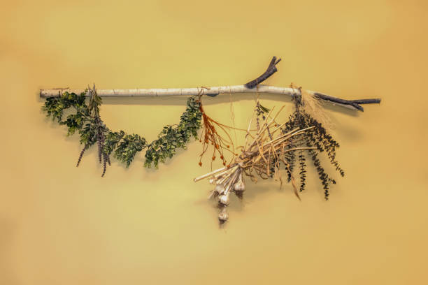 muro decorativo rústico colgante de rama con vegetación seca y ajo unido contra una pared amarilla - garlic hanging string vegetable fotografías e imágenes de stock