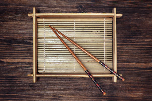 empty bamboo tray with chopsticks on a dark wooden table, concept of healthy oriental food