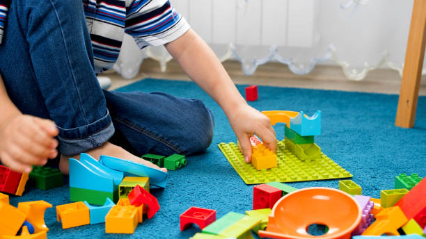 istock Closeup image of little boy assembling colorful toy constructor on carpet 1248631448