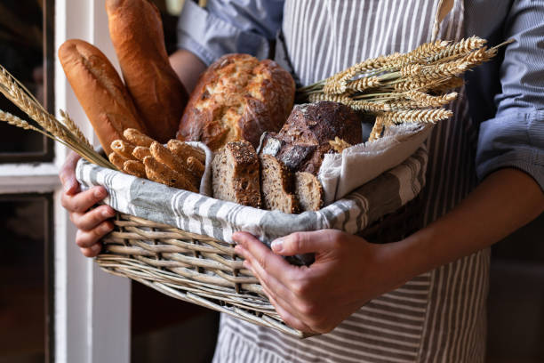 Concept of homemade bread, small bakery, natural farm products, domestic production. Healthy and tasty organic food. Woman holding basket with various bread freshly baked. Close up Concept of homemade bread, small bakery, natural farm products, domestic production. Healthy and tasty organic food. Woman holding basket with various bread freshly baked. Close up burgundy france stock pictures, royalty-free photos & images