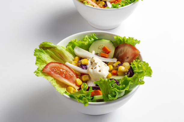 istock Fresh lettuce salad with tomatoes, red onion, corn, carrots, cucumber 1248635554