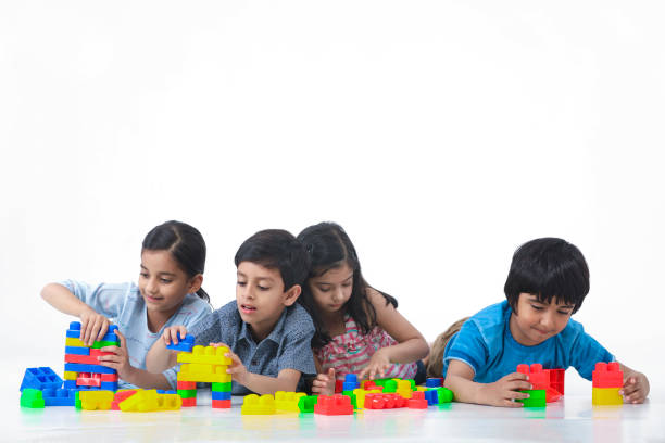 kinder spielen mit spielzeugblöcken gegen weißen hintergrund auf der vorderseite - cube baby child block stock-fotos und bilder