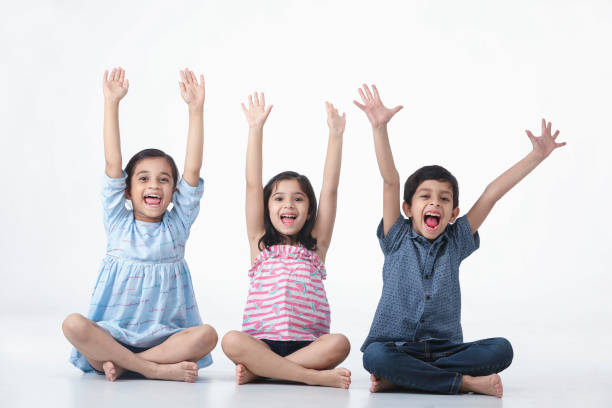 Kid Girls and Boy Sitting , Laughing, Smiling with hand held high